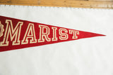 Vintage red felt Marist pennant showing beige 'RIST' letters and pointed end.