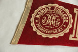 Vintage Marist felt pennant's left edge, cream binding, and visible pinhole.
