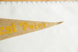 Tip of beige felt West Point pennant, yellow 'Point' lettering, and a small hole.