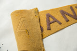 Folded edge detail of antique Albany felt pennant, patina purple letters on goldenrod yellow.