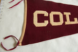 Maroon felt detail of vintage Colgate pennant with cream 