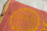 Detail of vintage USC felt pennant, with yellow emblem, dark stains, and discolored binding.