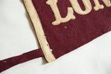 Detail of the antique Long Beach felt pennant's maroon body and worn cream edge.
