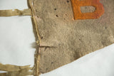 Antique B U S felt pennant close-up: beige wool, orange B, distressed texture.