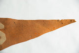 Pointed end of the antique orange felt pennant with aged texture and small perforations.