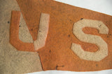 Aged orange wool felt detail of antique B U S pennant, featuring off-white letters.