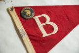 Weston Trojans pin, grommet, and Taylor Made label on vintage red felt pennant.