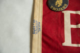 Aged red felt texture of the vintage Weston Trojans pennant with a partial white letter.