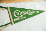 Green felt pennant showcasing cream 'Grand Canyon Arizona' vintage lettering.