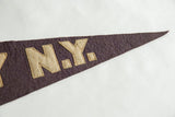 Beige felt N.Y. block letters sewn onto the dark, faded blue antique pennant.