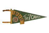 Vintage 1948 The 7 Caves green felt pennant with yellow numerals, cream script, storied patina.
