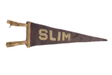 An antique dark purple felt pennant with tan sewn letters spelling SLIM.