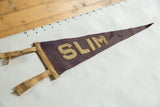 Angled view of the antique SLIM felt pennant showing texture, staining, and hand-drawn ruler markings.