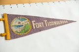 Faded purple felt Fort Ticonderoga pennant with circular fort graphic and beige lettering.