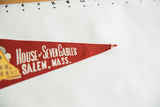 Pointed end of the vintage red felt pennant, showing fraying and a small tear.