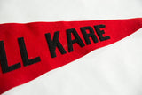 Black 'KARE' letters sewn onto the vintage red felt Kamp Kill Kare pennant.