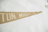 Pointed end of tan vintage felt pennant with white 'TON, MASS' lettering and subtle wear.