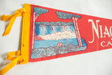 Yellow felt ties and aged red texture of a vintage Niagara Falls pennant.