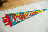An angled view of the vintage Plymouth Mass. felt pennant showing its full length.
