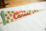 Aged beige felt pennant showcasing red Canada text and colorful provincial shields.