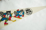 Vibrant raccoons playing winter sports on vintage felt Lake Placid 1980 Olympic pennant.