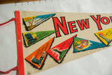 Vintage New York City felt pennant detail: colorful landmark flags, red felt binding.