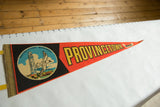 Circular emblem on red felt pennant featuring Provincetown Monument and seagull.