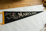 Black felt Maryland pennant with yellow trim, ivory text, and colorful state landmarks.