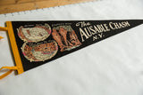 Black felt souvenir pennant detail showing Rainbow Falls, The Flume, and yellow trim.