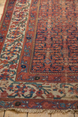 Vintage Malayer rug corner, navy and red Herati field with aged ivory meandering vine border.