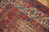 Worn corner of vintage Malayer rug, featuring red Herati and blue vine motifs.