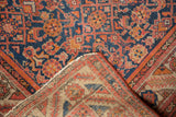 Vintage Malayer rug's abrashed Herati motif pile, folded showing its hand-knotted foundation.