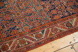 Malayer rug's geometric serrated leaf border, Herati field, madder red, cobalt blue, and subtle wear.