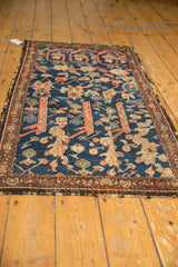 Antique Fereghan rug detail: madder root red, navy floral motifs, tattered bottom edge.