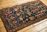 Antique Fereghan rug fragment's intricate border with madder red, ivory, and tattered edge.