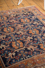 Antique Afshar rug's rust border and navy floral field, with visible knot head wear.