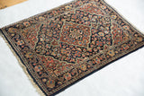 Angled view of a vintage Sarouk rug showing its intricate floral field and central medallion.