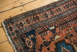 Kurdish Hamadan rug corner, low pile with visible knot heads, terracotta and navy geometric border.