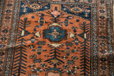 Vintage Kurdish Hamadan rug detail: tribal geometric motifs, terracotta, navy, and low pile texture.