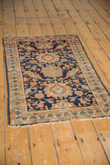 Vintage Persian Hamadan rug corner with navy field, faded blush motifs, and fringed edge.
