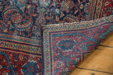 Mahal rug folded corner showing intricate Herati motif, oversized Serbend border, and visible foundation wear.