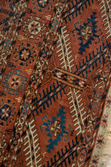 Antique Turkmen Tekke rug detail: brick red and navy geometric gul motifs, low pile, knot heads.