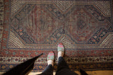 Antique Qashqai rug: geometric field patterns in madder red, navy, showing mostly even wear.