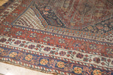 Antique Qashqai rug's madder red, navy, ivory borders with playful motifs and pile wear.