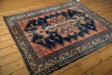 Blush and navy floral borders with visible wave motif on vintage Malayer rug.