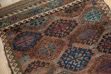 Antique Belouch runner's geometric gul motifs in copper, navy, and powder blue, with kilim edge.