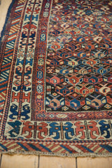 Antique Caucasian rug corner detail: geometric borders, navy, rose, ivory simplistic boteh field.