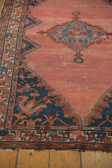 Vintage Malayer rug corner: oversized navy floral spandrel on blush field, intricate border.