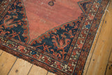 Vintage Malayer rug corner detail showing blush rose field, navy floral spandrel with serration.