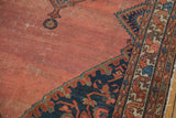 Abrashed blush rose field with navy floral spandrel and detailed zoomorphic border on vintage Malayer rug.